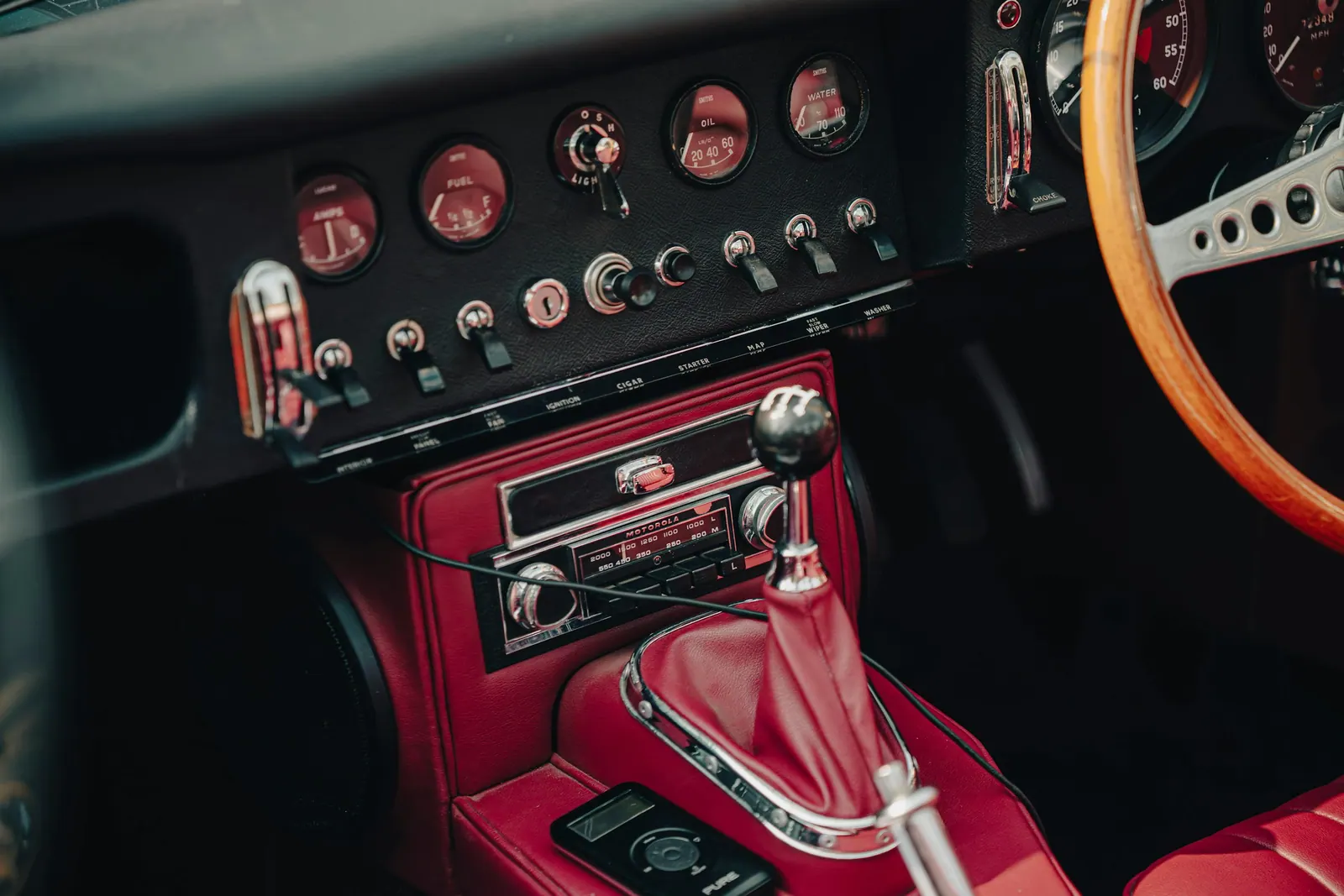 Interior clássico com couro vermelho e volante de madeira