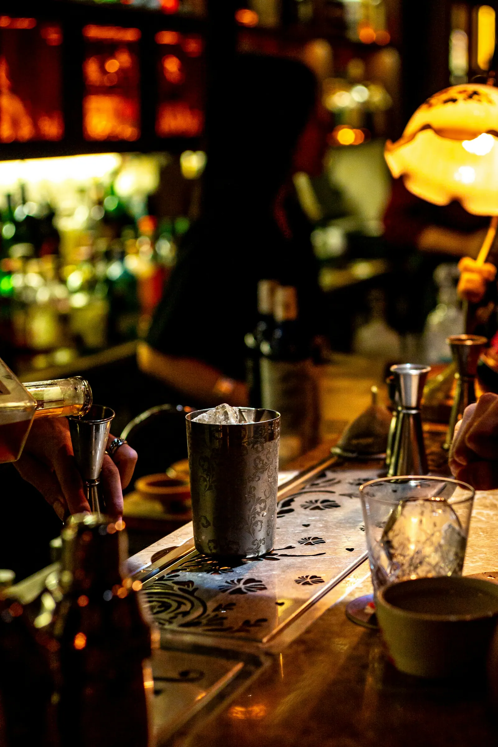 Balcão de bar com luz quente e garrafas ao fundo