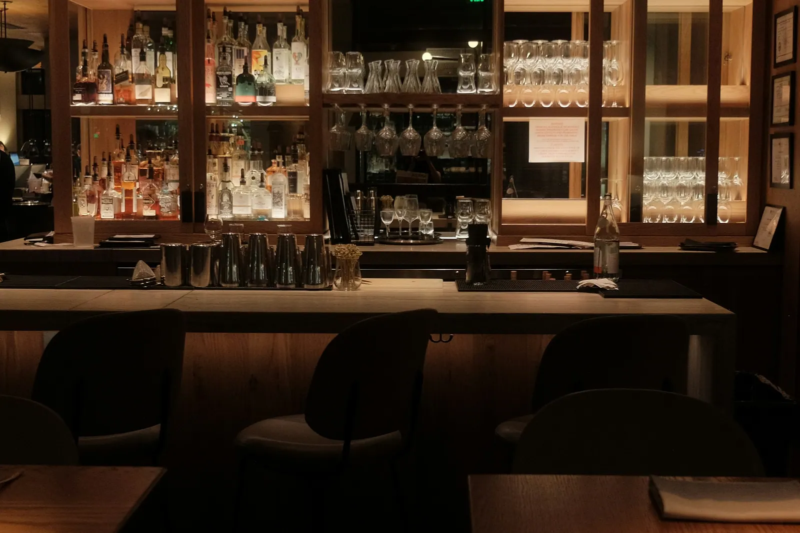 Bar antes de abrir, com prateleiras de taças e garrafas