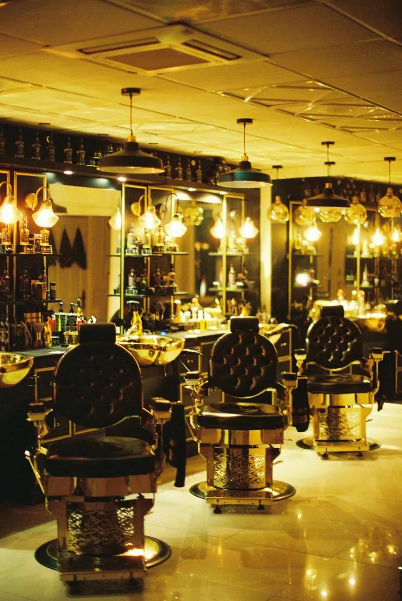 Salão de barbearia iluminado em tons dourados