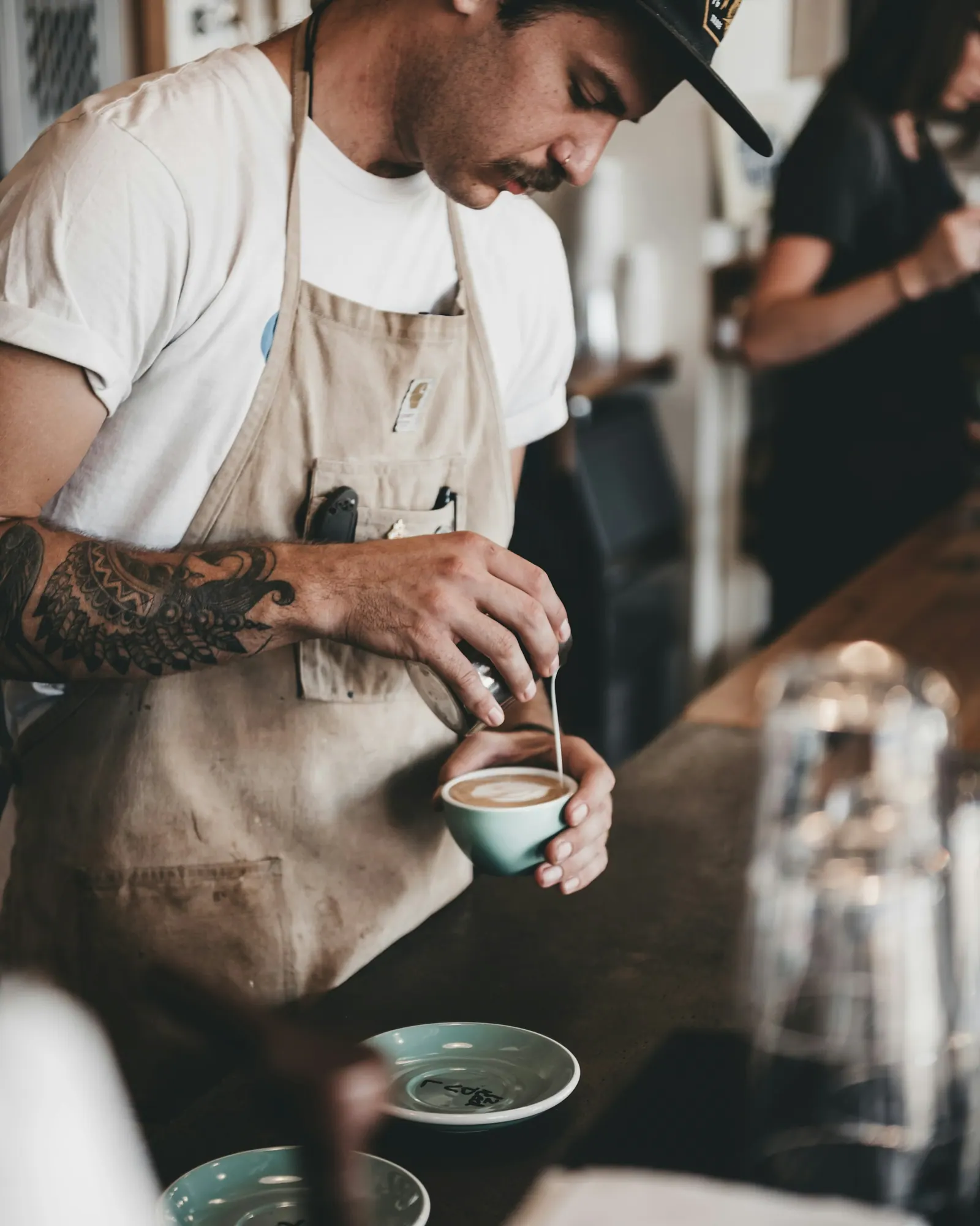 Barista de avental preparando café no balcão