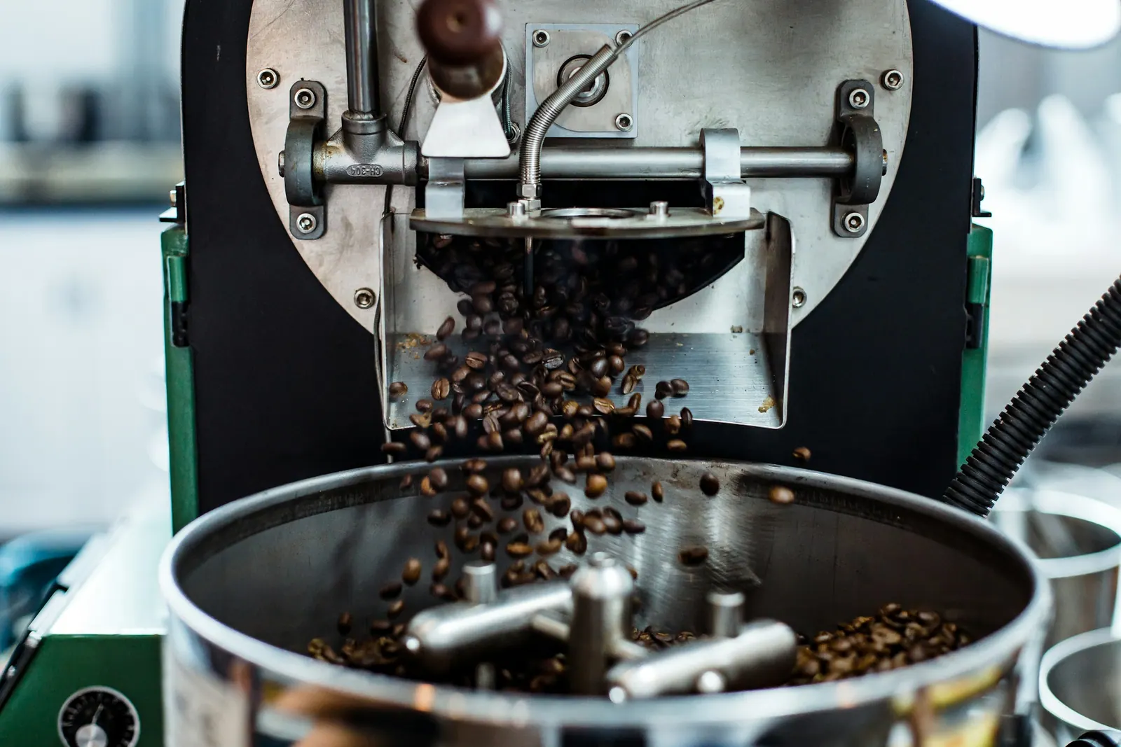 Grãos de café caindo no resfriador do torrador