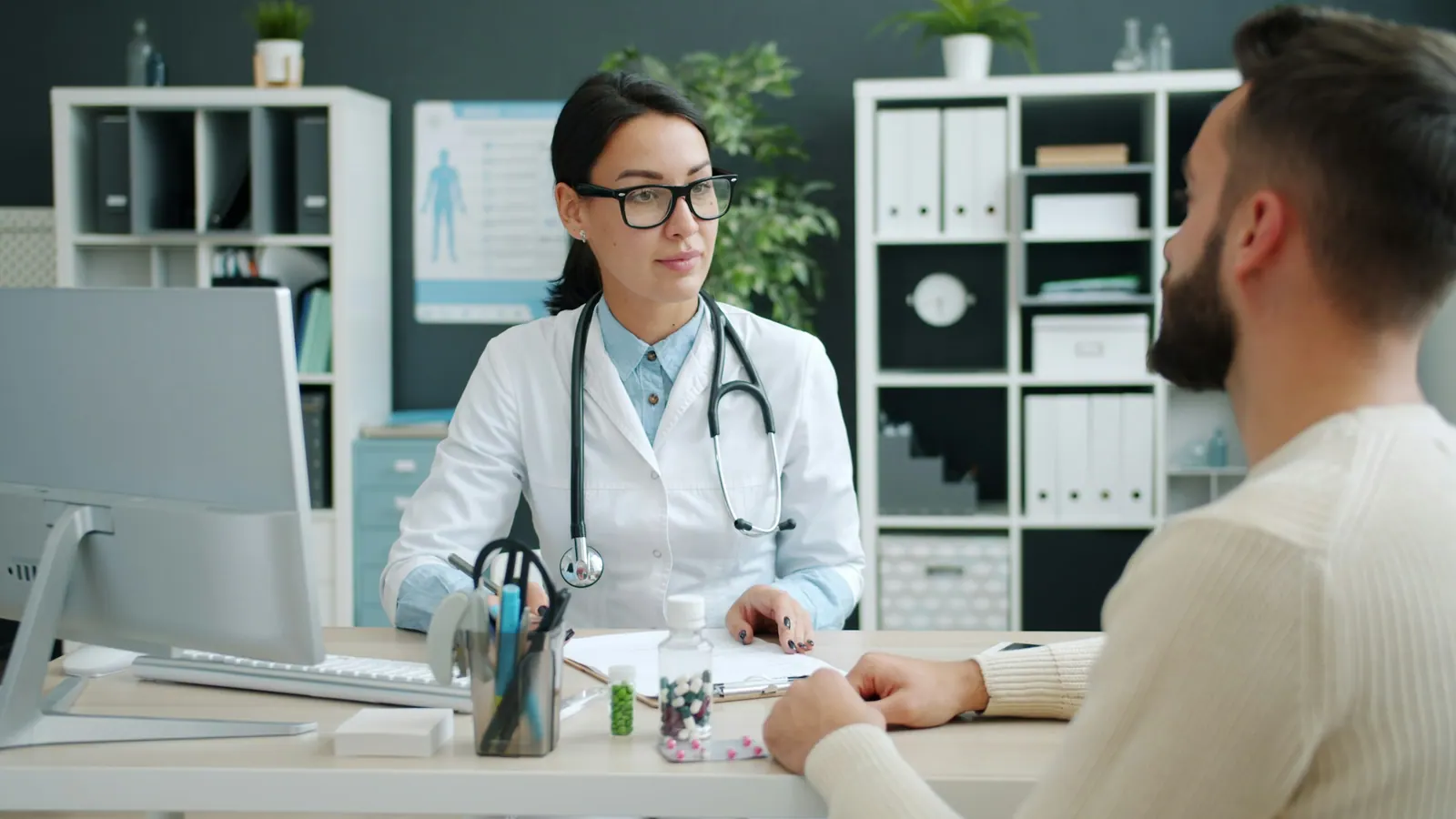 Médica sorrindo durante uma consulta no consultório