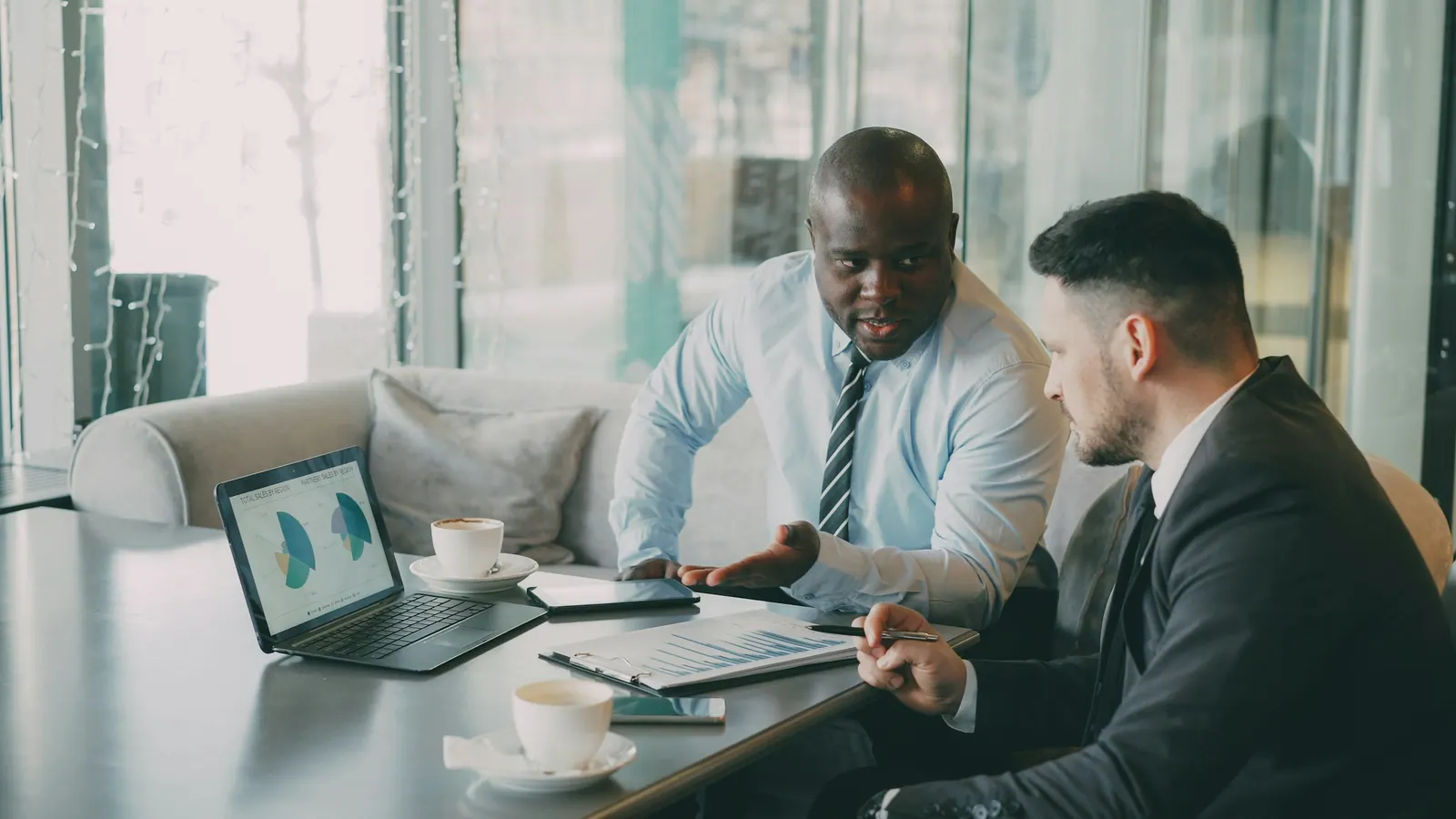 Consultor mostrando gráfico no notebook para o cliente
