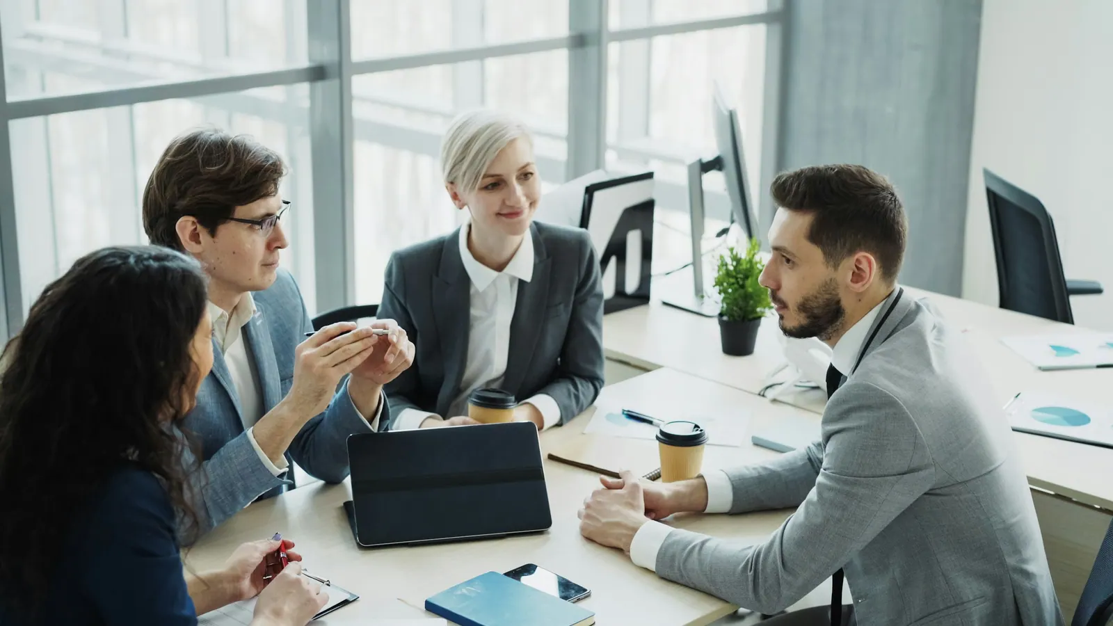 Reunião de trabalho com tablet e cafés sobre a mesa