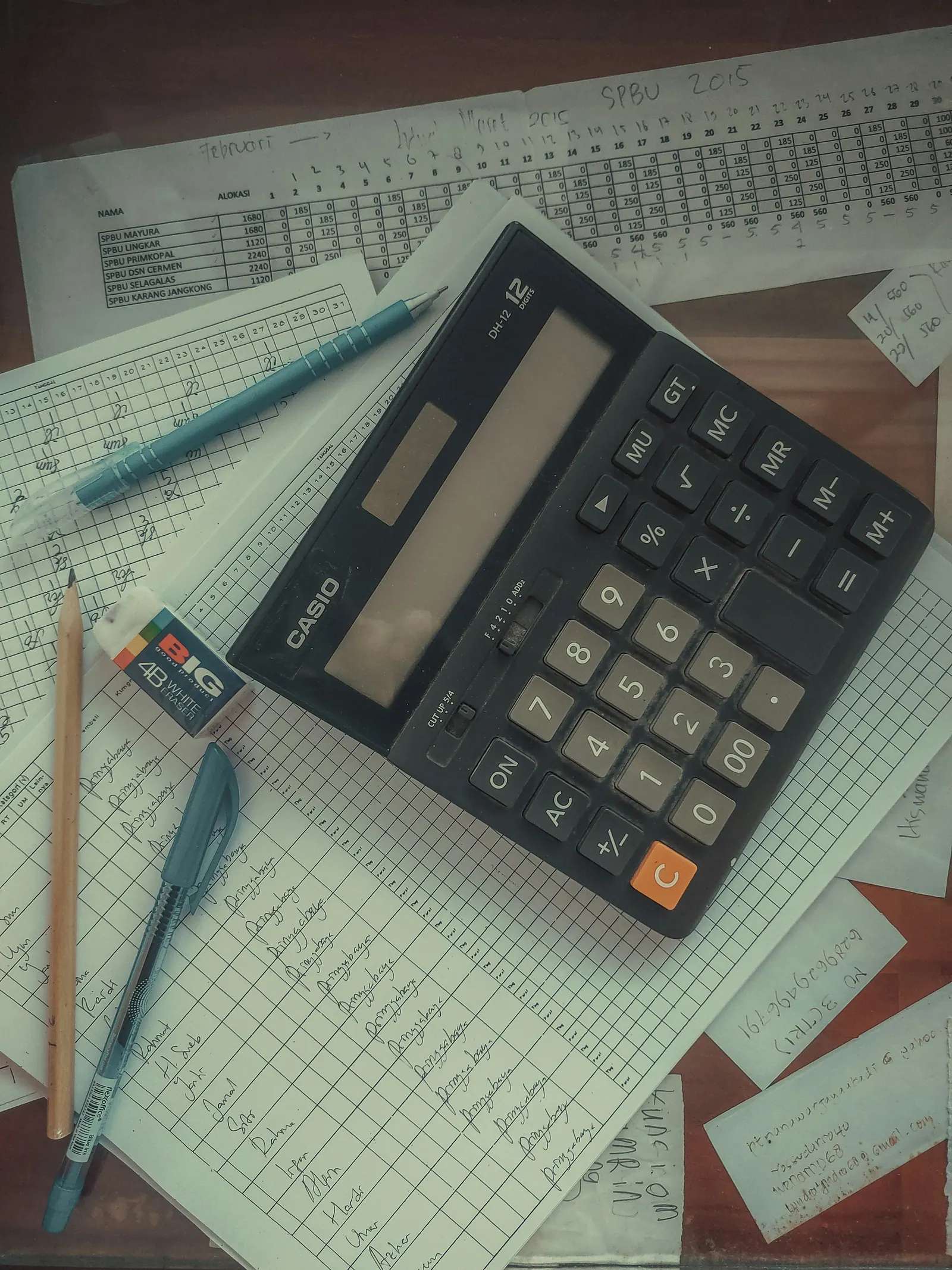 Calculadora sobre planilhas e anotações, vista de cima