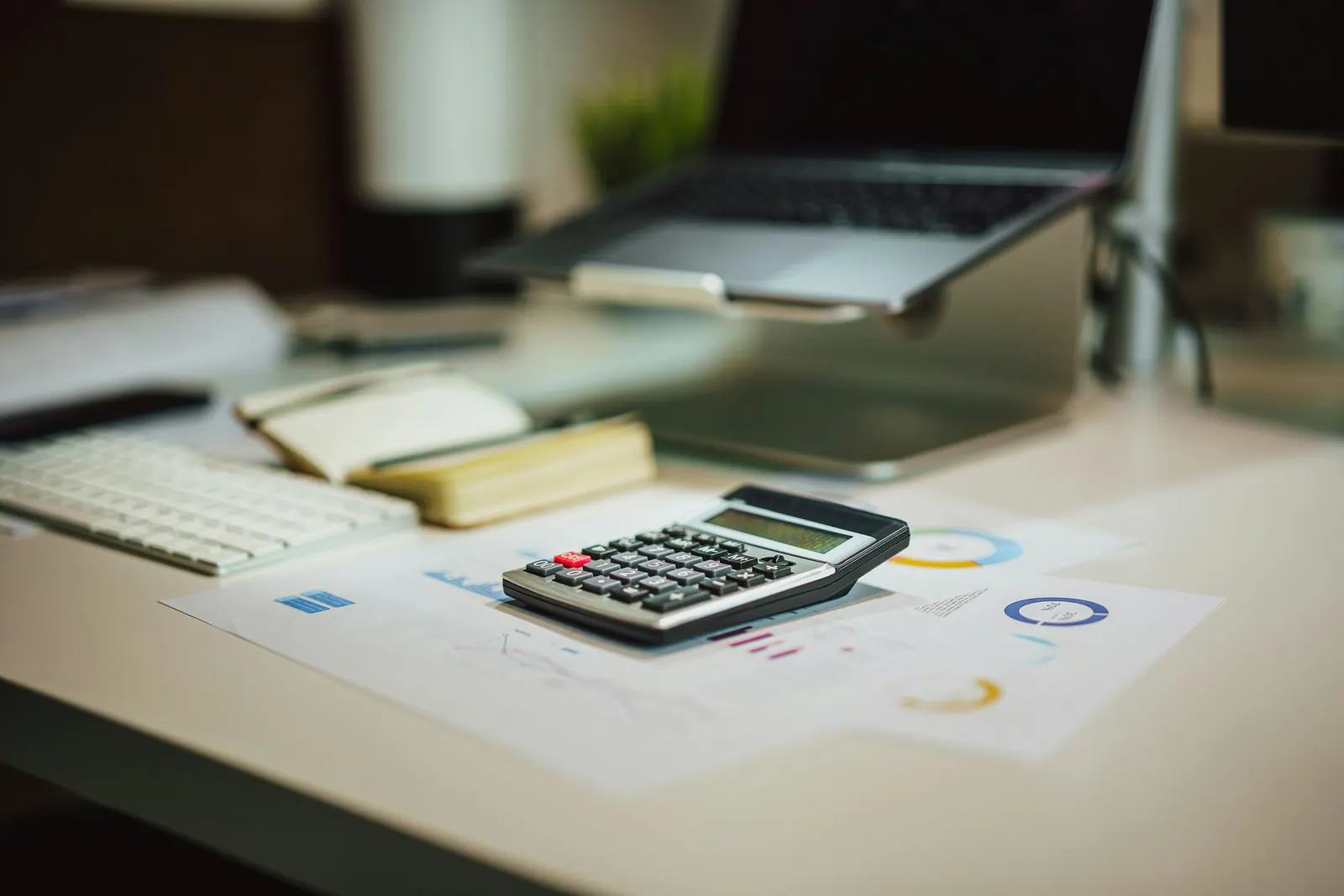 Mesa de trabalho com calculadora e relatórios do mês
