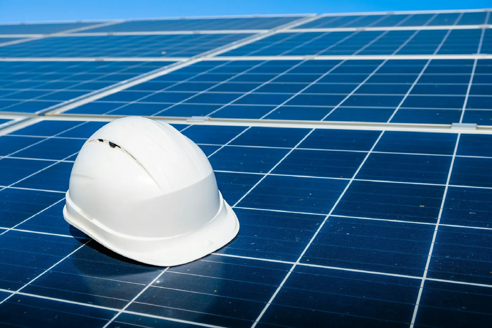 Capacete de segurança apoiado sobre um painel solar durante a vistoria