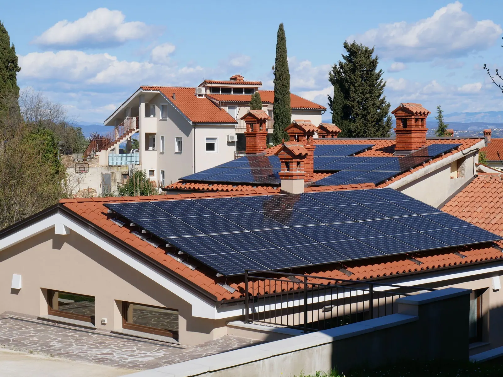 Casa de telhado vermelho com sistema de painéis solares instalado