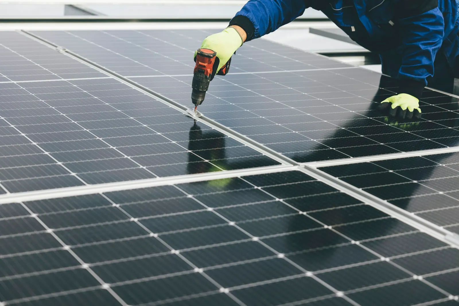 Instalador parafusando a estrutura de fixação de um painel solar