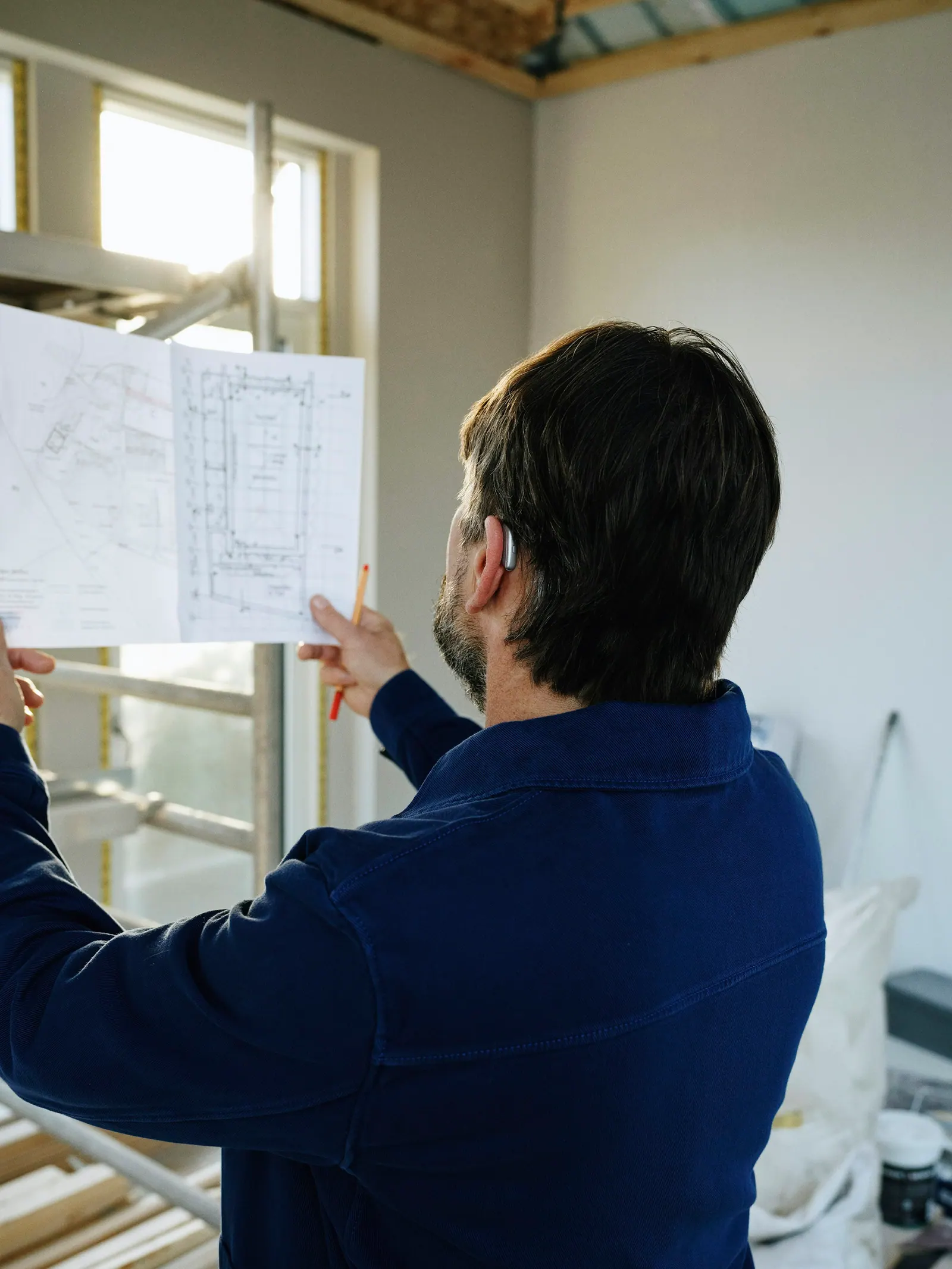 Engenheiro analisando o projeto junto à janela