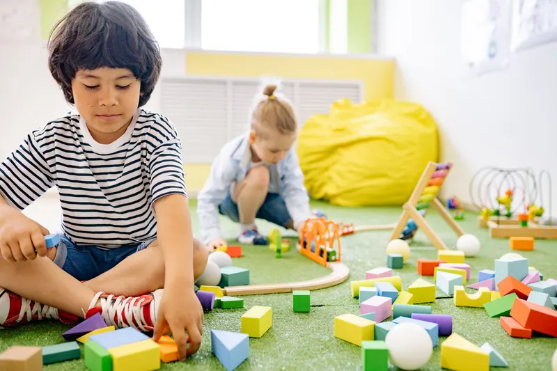 Meninos brincando com blocos de madeira no tapete