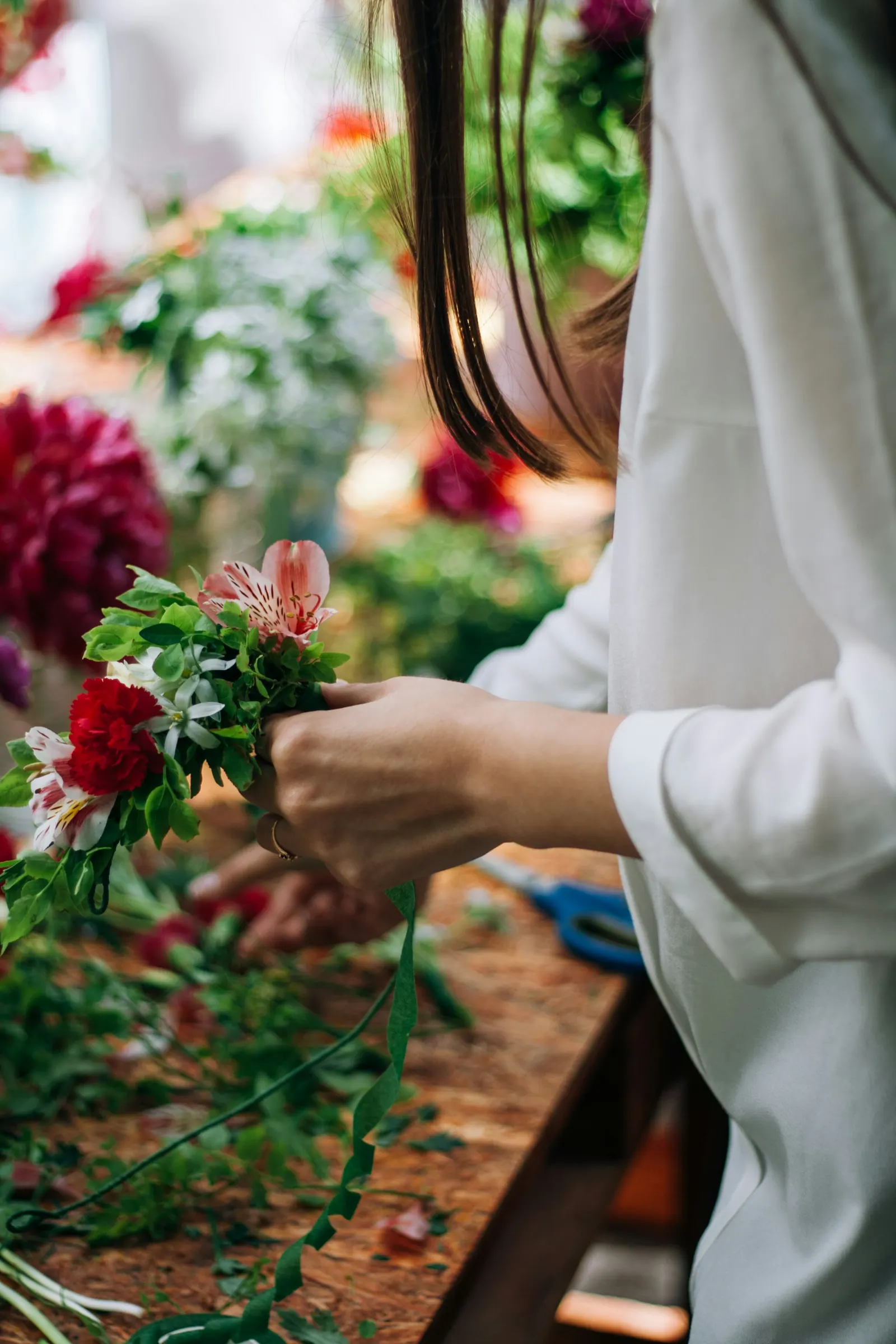 Mãos cortando os caules das flores no balcão