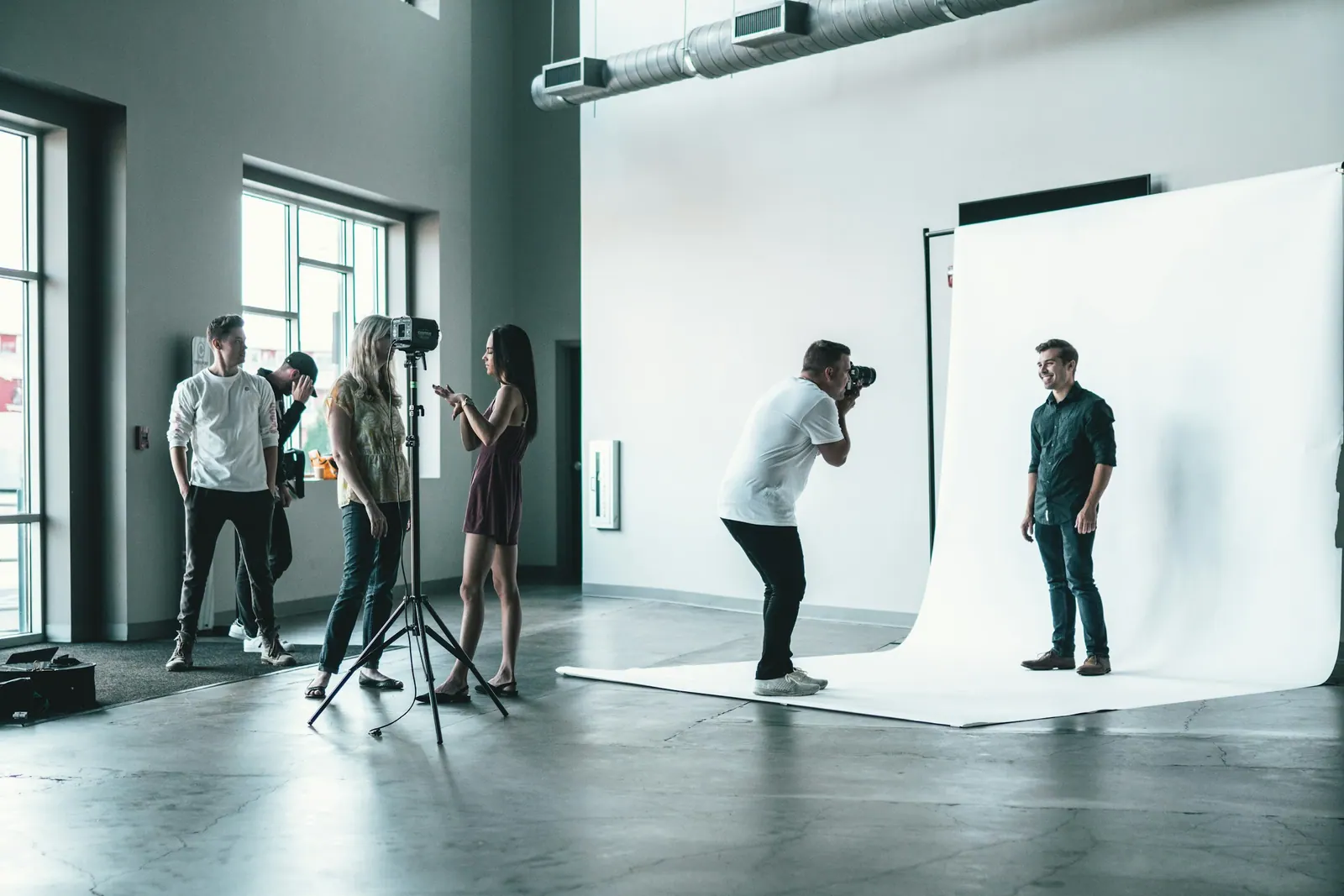 Equipe fotografando um ensaio em estúdio com fundo branco