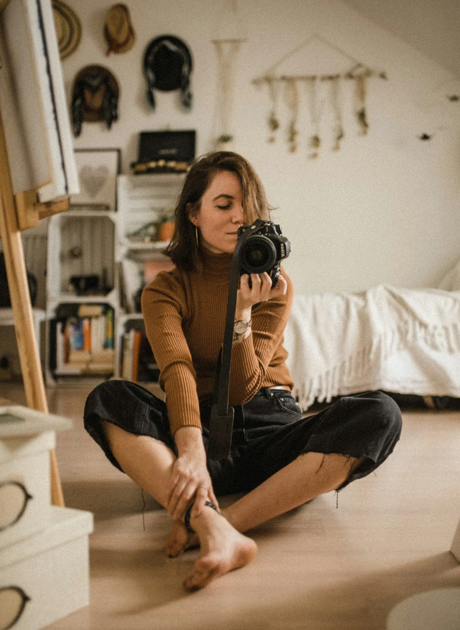 Fotógrafa sorrindo com a câmera em casa