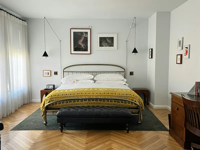 Quarto claro com cama de ferro e colcha amarela