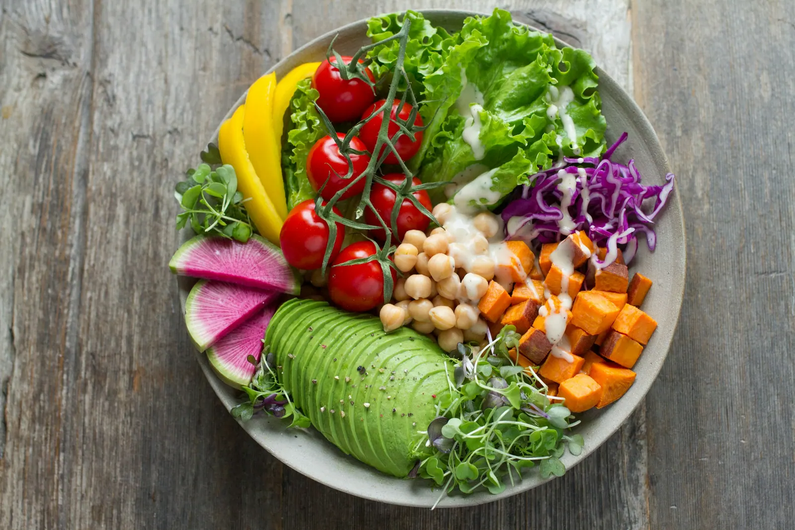 Tigela colorida com grão-de-bico, legumes e folhas