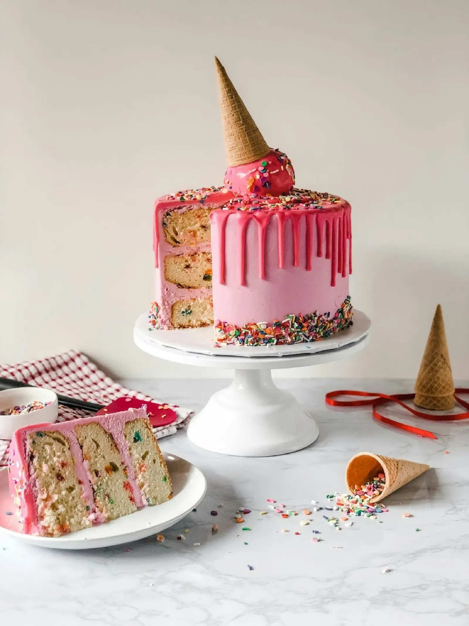 Bolo confeitado rosa com fatia servida ao lado