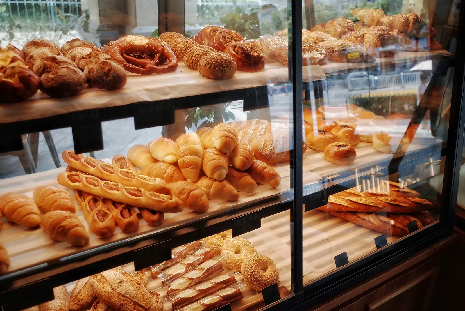 Vitrine de padaria com pães e folhados nas prateleiras de vidro