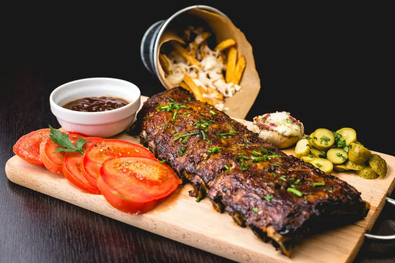 Costela assada servida com tomate, picles e molho