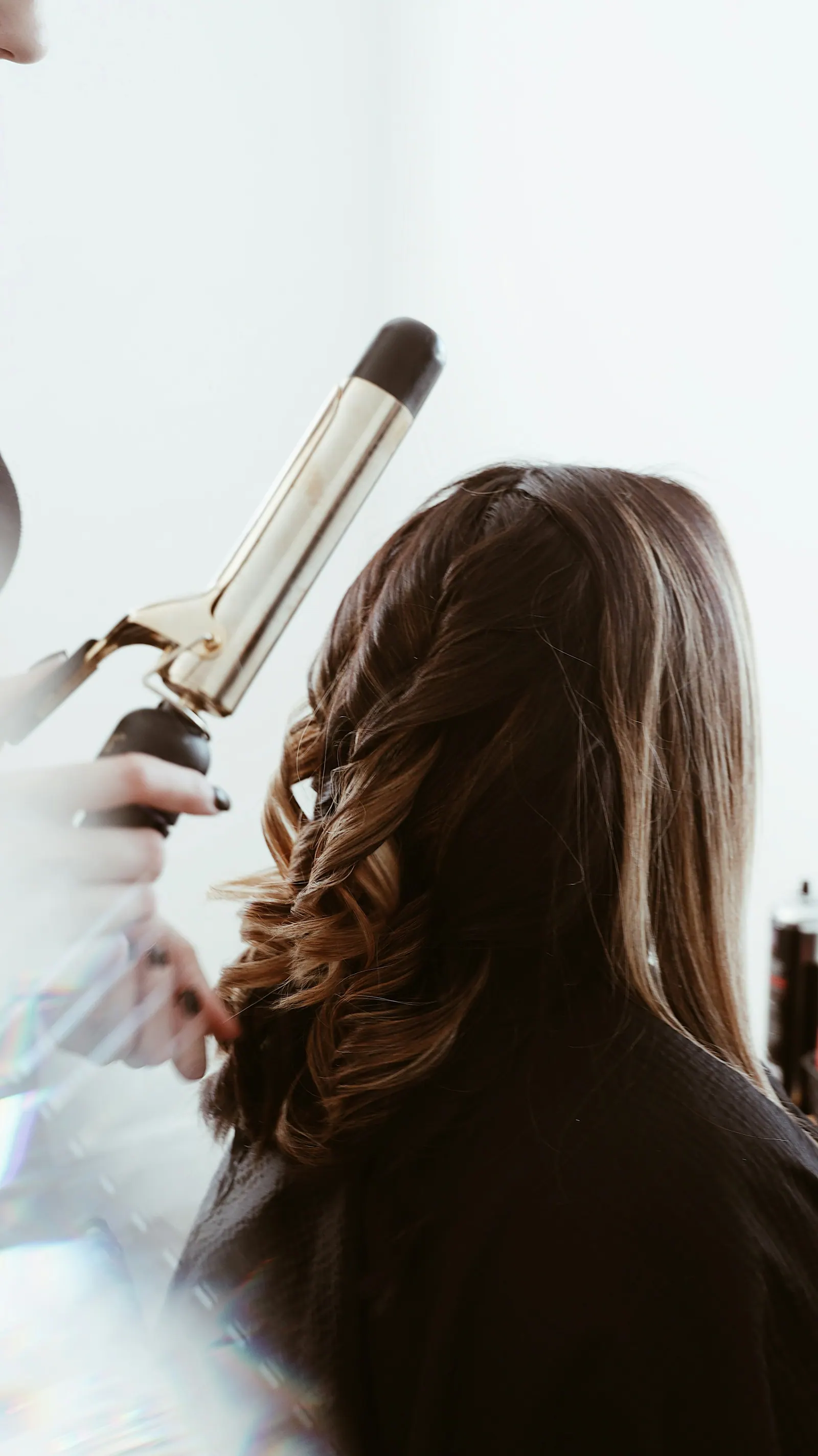 Cabeleireira modelando cachos com babyliss