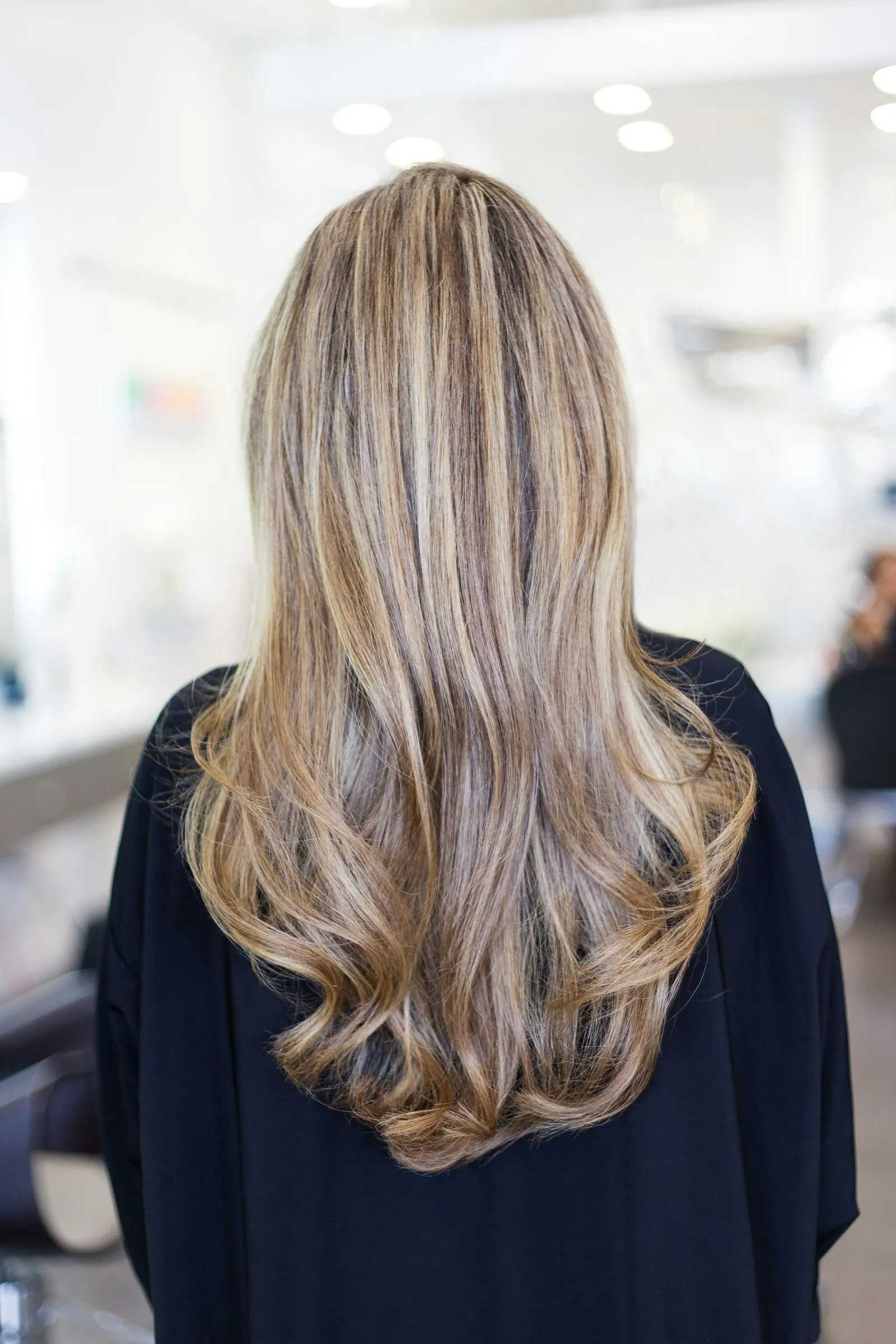 Cabelo loiro longo e ondulado visto de costas