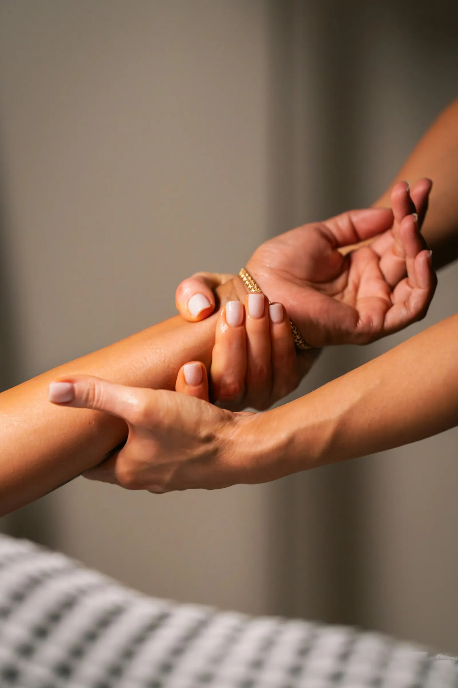 Terapeuta massageando o antebraço da cliente