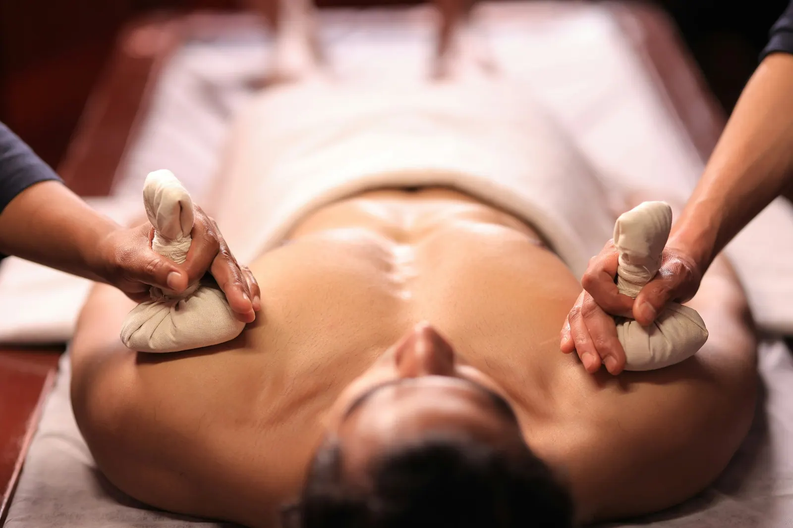 Massagem com pindas de ervas aquecidas