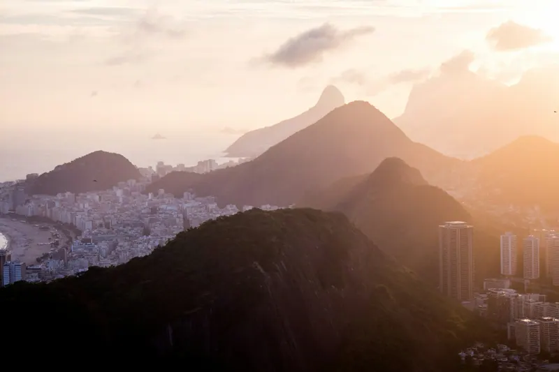 Morros e praia em contraluz no fim de tarde